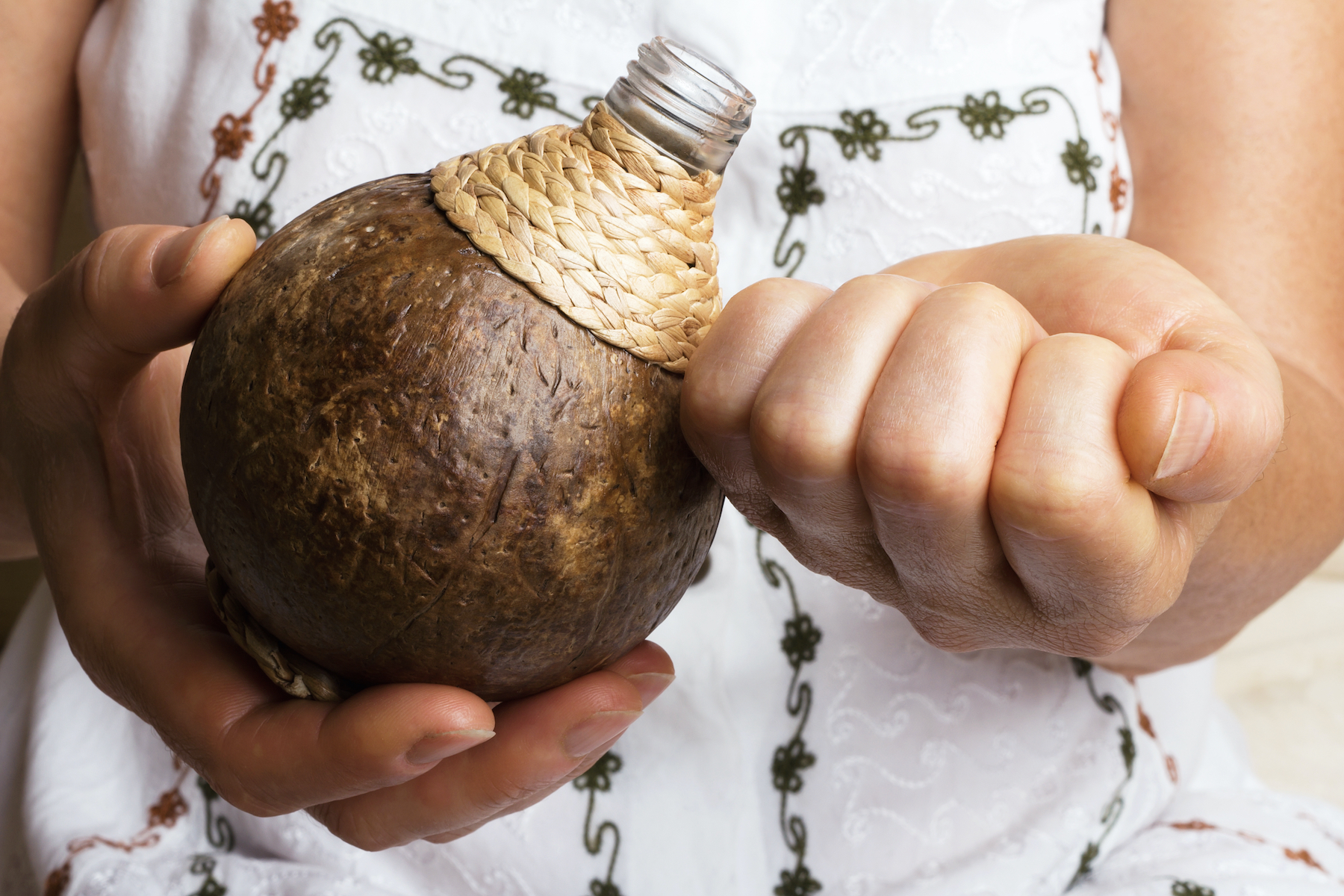 Close up of hands holding a coconut