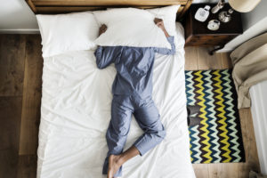 Man laying face down on a bed