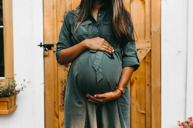 pregnant black woman holding her round belly