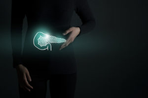 A person wearing all black clothing with a neon outline of where the pancreas is located