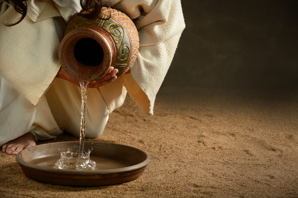 water being poured from a clay jug