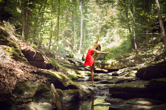 Beautiful woman ballerina dance in old wood in stream